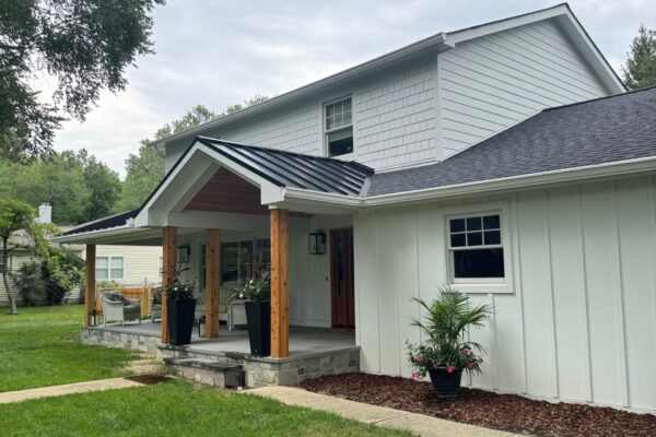 portico with a metal roof and white siding